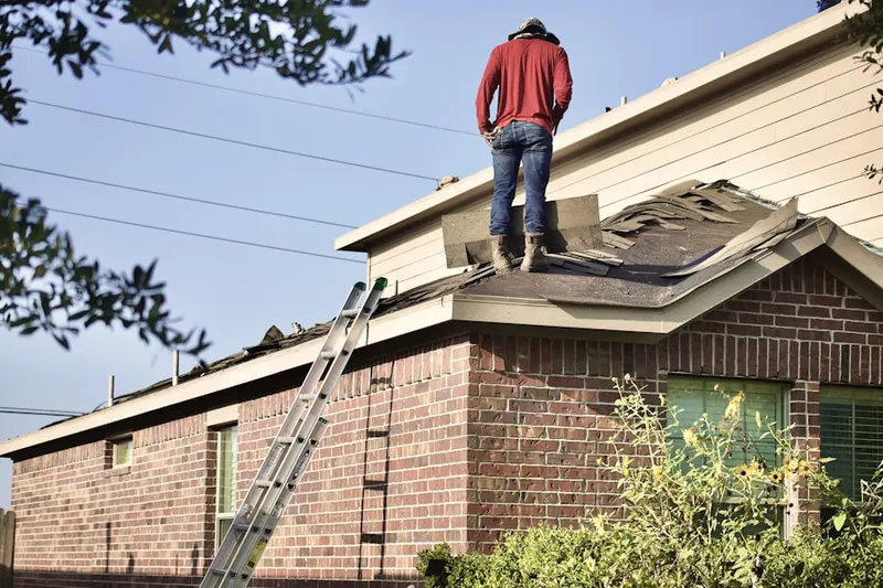 Professional roofer working on a residential roof in Woodfern